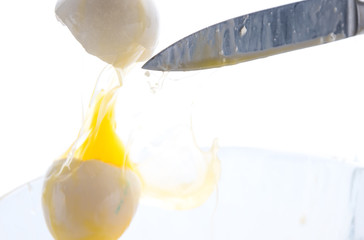 The falling egg breaks on the blade of a knife