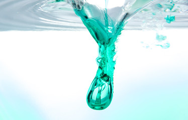 Underwater splash from falling dark green syrup