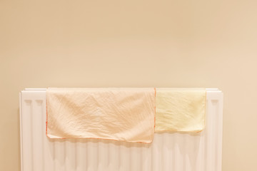 Towels drying on radiator at home pale pastel neutral colour