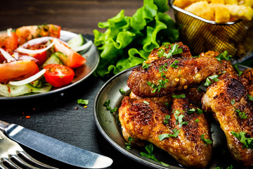 Roast chicken wings with french fries and vegetable salad 