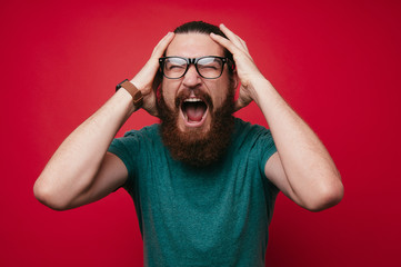 screaming bearded brutal man and looking at the camera with hands up goal winner celebrating