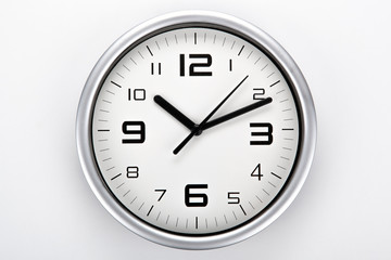 white clock face with black digits on a gray background closeup