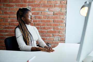 clever African stylish girl with good manners sitting at the table. close up side view shot. copy space