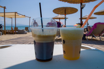 Coffee drink and a cool homemade lemonade on a plastic table in a beach bar