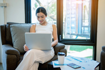 young business woman working at a coffee shop with a laptop. She drinking a coffee and use digital computer.