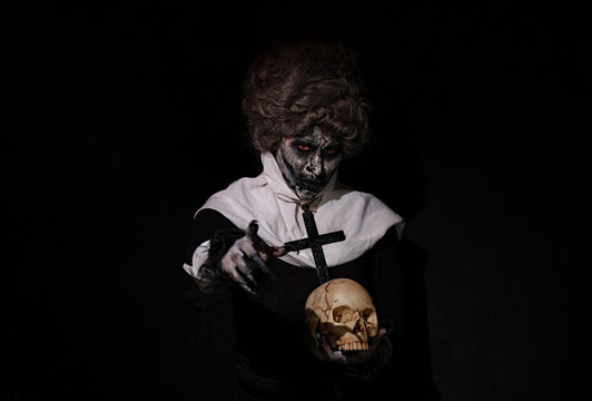 Woman Halloween theme nun holding Skull