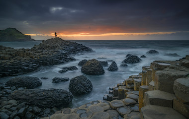 Sonnenuntergang am Giant's Causeway mit Person - Nordirland