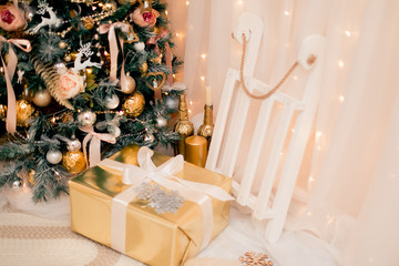 Luxury new year decor. Beige, light pink, golden, silver Christmas tree decoration. Merry Christmas and Happy Holidays! Bright lights and white interior.