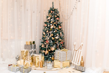 Luxury new year decor. Beige, light pink, golden, silver Christmas tree decoration. Merry Christmas and Happy Holidays! Bright lights and white interior.