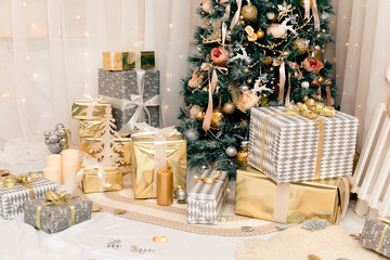 Luxury new year decor. Beige, light pink, golden, silver Christmas tree decoration. Merry Christmas and Happy Holidays! Bright lights and white interior.