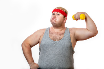Ironic portrait of plump fat man dressed in casual singlet holding a small yellow dummbell in such manner as if he lifting heavy weights