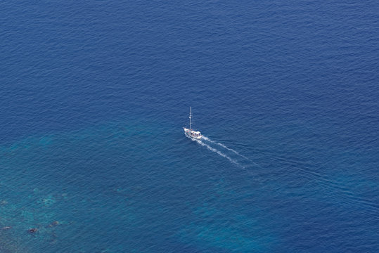 View from above on the single sailing boat in open sea © Dennis Gross