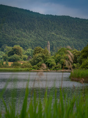 Alter Turm am See in hügeliger Waldlandschaft - Glendalough - Irland