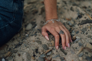 the hand of the girl with the ring in the sand