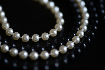 Black and white beads necklace on a dark background close up