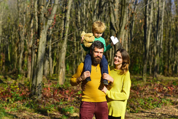 Fototapeta premium Family group of father, mother and child on walk outdoor. Group of people smile in spring park. Enjoy a healthy dose of nature