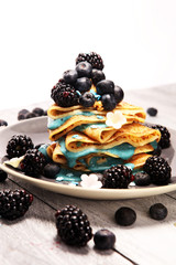 Delicious Tasty Homemade crepes or pancakes with blackberries,blueberries and blue spirulina nicecream.