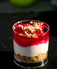 Leckere Erdbeercreme auf Joghurt und Kekskrümeln in kleinem Glas geschichtet