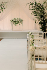Hotel wedding ceremony. Decor Studio. white wooden chairs on a green lawn. Wedding festal arch. White armchairs for guests