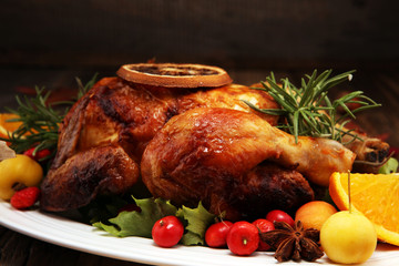 Baked turkey or chicken. The Christmas table is served with a turkey, decorated with fruits, salad and nuts. Fried chicken, table. Christmas dinner