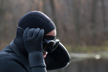 Fisherman in wetsuit in autumn forest. Close up