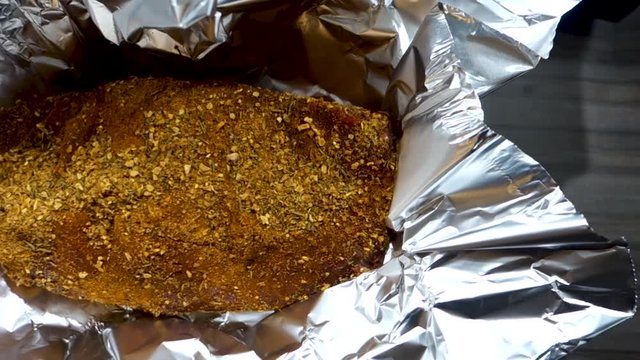 Roast beef in aluminum foil with spices on it waiting to be put in the owen