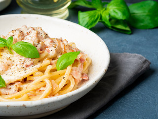 Carbonara pasta, spaghetti with pancetta, egg, parmesan cheese, cream sauce. Traditional italian cuisine. Side view, close up