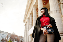 African american fashion girl in coat and newsboy cap posed at street.