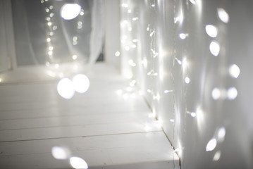 Holiday background and lighting concept - blurred white christmas decoration or garland bokeh lights.