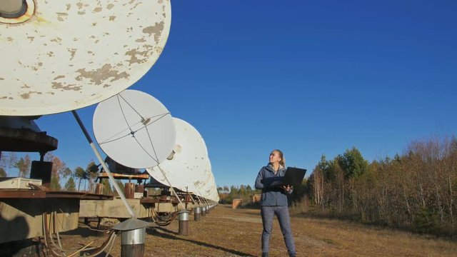 Woman student operator of institute of Solar Terrestrial Physics monitors communication equipment in notebook. Unique array solar radio telescope. Sun Solar Radio Telescope. The 'Quasar' observatory