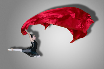 Ballet dancer jumping with fabric on studio