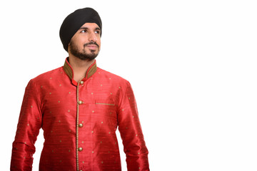 Young handsome Indian Sikh thinking while wearing traditional cl
