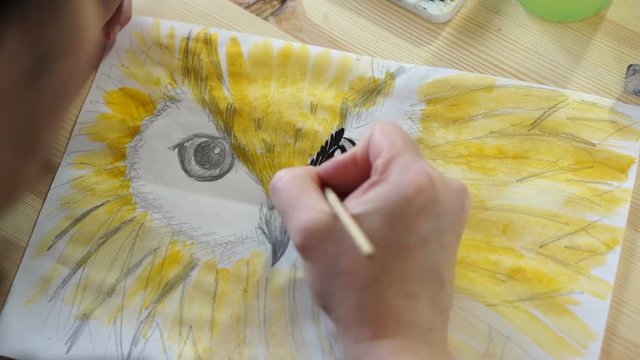 The artist draws the beak of a bird
