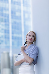 Sad girl standing with a laptopin the middle of the business word. A woman fired from her job