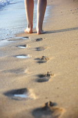 Woman walking on sandy beach. Beach travel - Summer vacations concepts, woman legs on sand