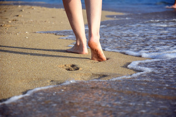 Woman walking on sandy beach. Beach travel - Summer vacations concepts, woman legs on sand