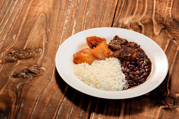 Meal with rice, beans, roast beef and baked potato
