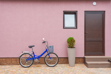 Fototapeta na wymiar bike near the wall with a doorway and a window, part of the pavement