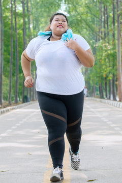 Fat female jogger doing a workout on the road