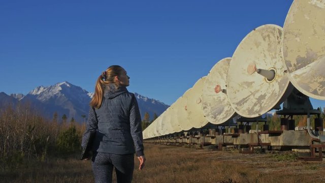 Woman student operator of institute of Solar Terrestrial Physics monitors communication equipment in notebook. Unique array solar radio telescope. Sun Solar Radio Telescope. The 'Quasar' observatory