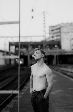 barechest young man on a railway