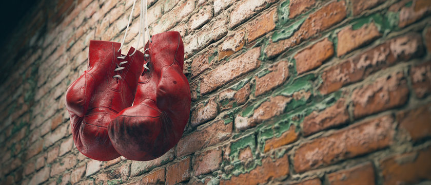 Old red boxing gloves hang on nail on brick wall with copy space for text. High resolution 3d render