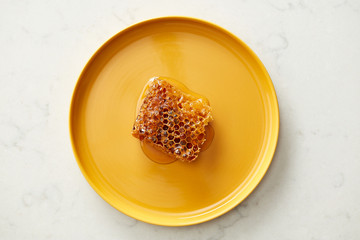 Sweet and fresh honeycomb on bright plate.