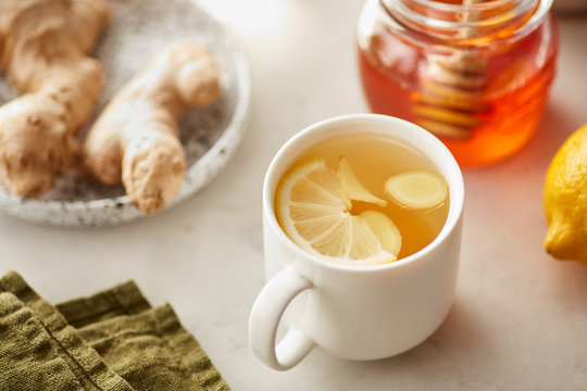 Still life of hot drink with lemon, ginger root and honey.