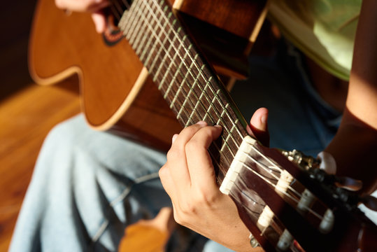 Woman playing guitar in close-up.
