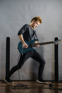 Young man playing electric guitar