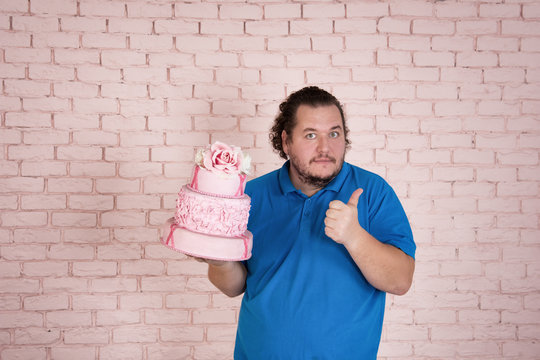 Funny cook at work. Cake and pink background. 