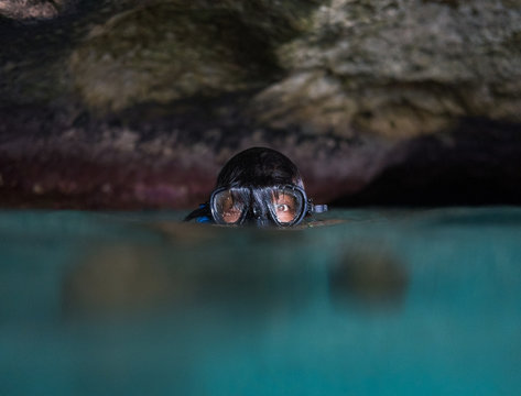 Curious woman with dive mask looking surprised while snorkelling.