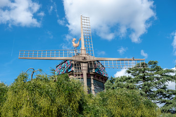 weather vane on old windmill at blue sky background