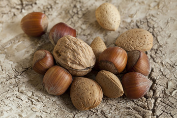 Autumn still life with walnut, almonds and hazlenuts on rustic background